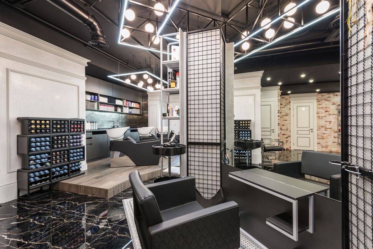 A black leather styling chair in front of a salon mirror