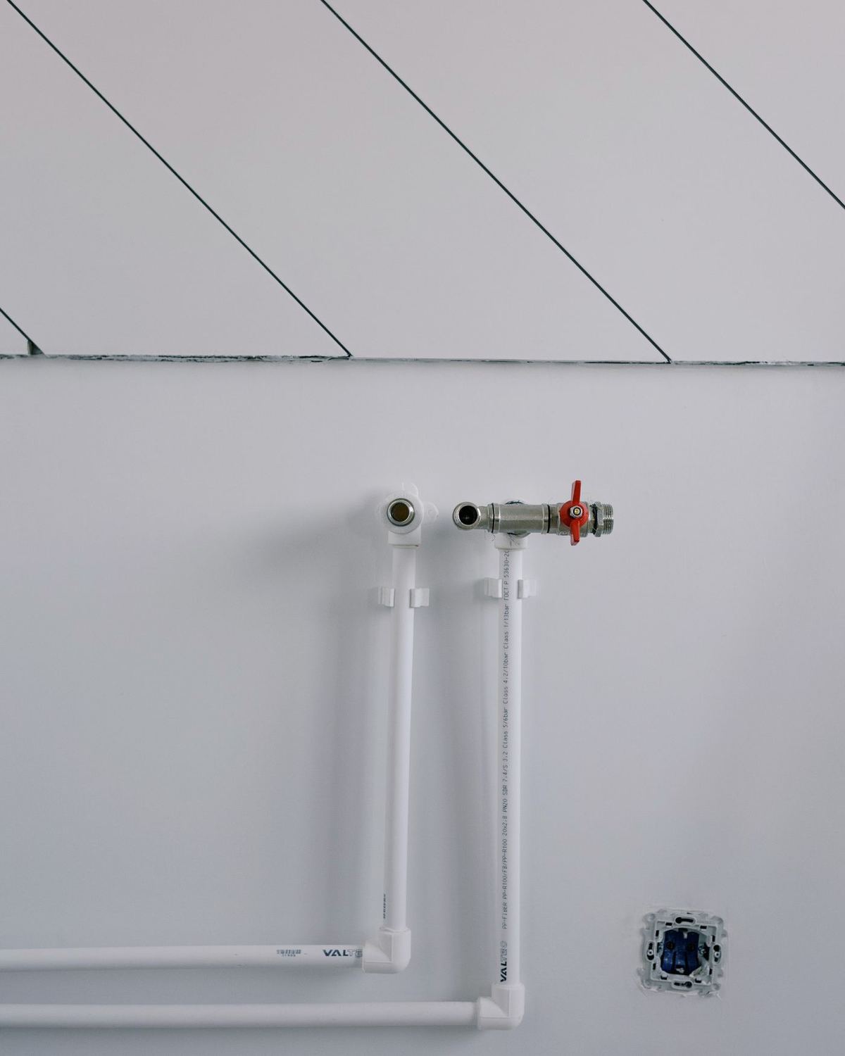 Clean pipework run neatly along a white wall