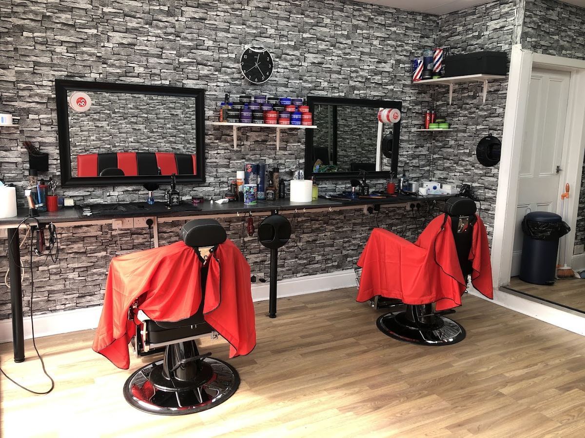 A barber chair with a red cape inside Cleancut barber shop