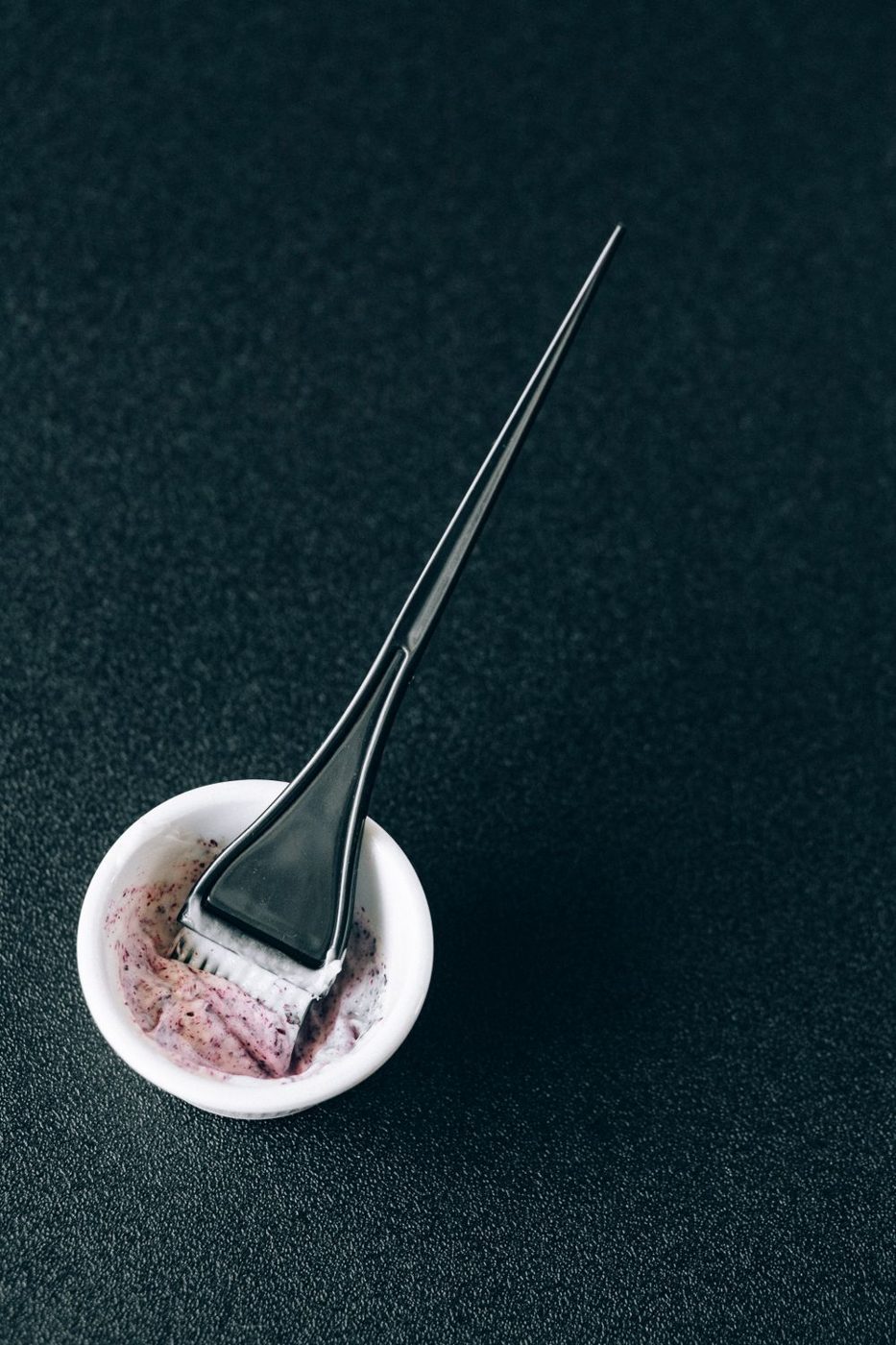 A tint brush resting in a colour bowl
