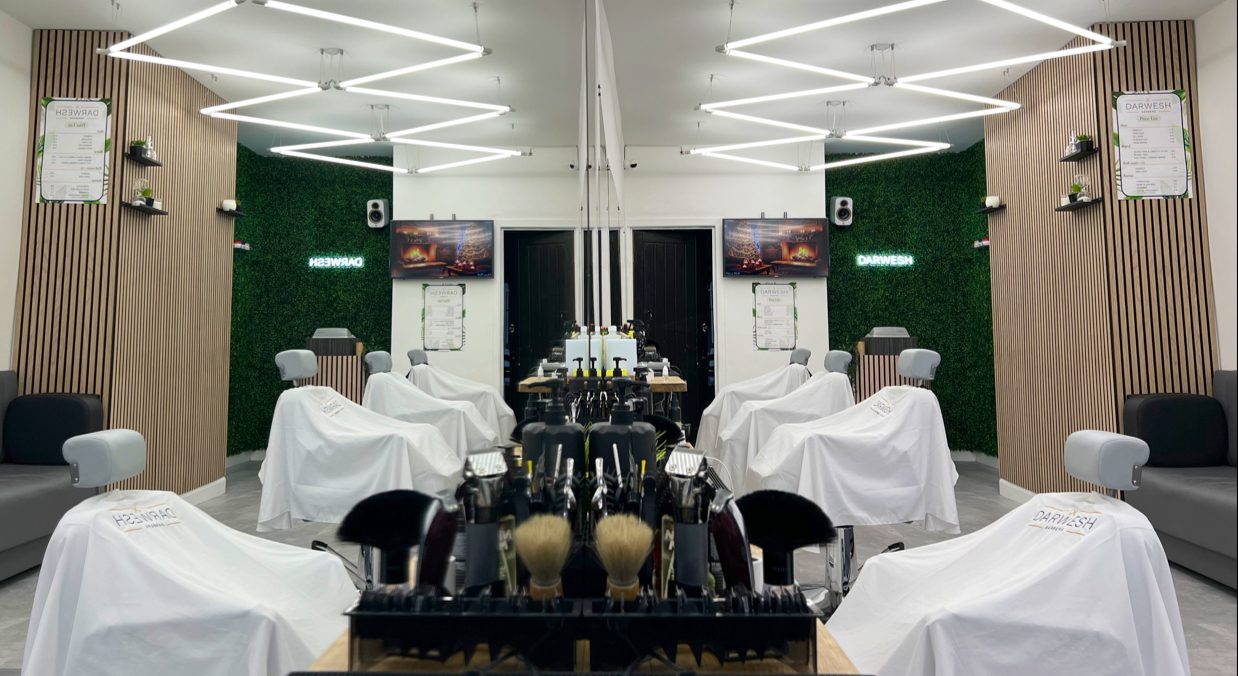 Inside Darwesh Barbers, chairs down both sides against a green wall