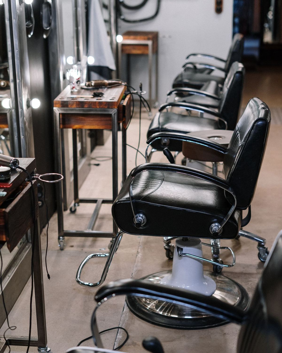 A row of barber chairs in front of mirrors