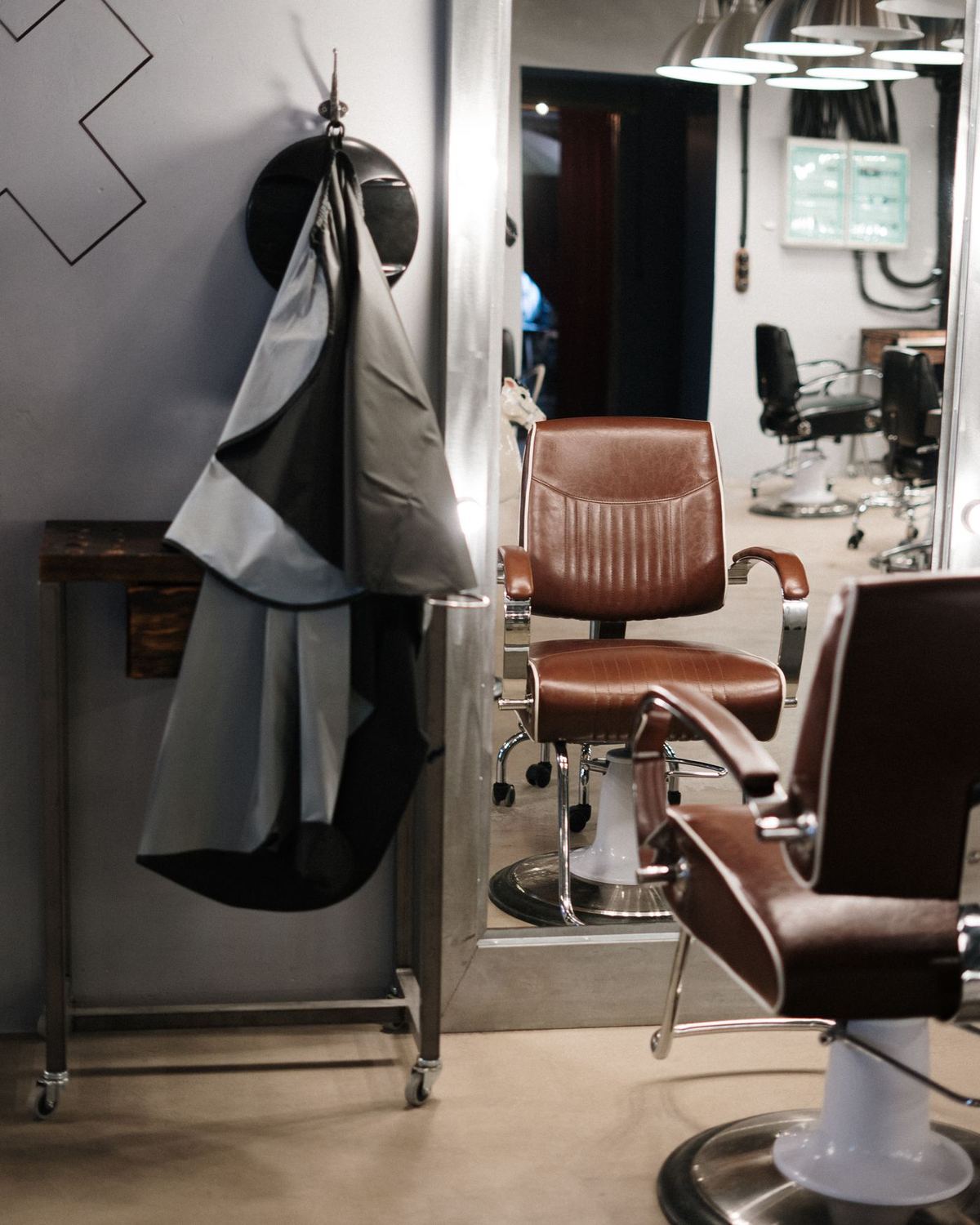 A barber chair with a cape hanging beside it
