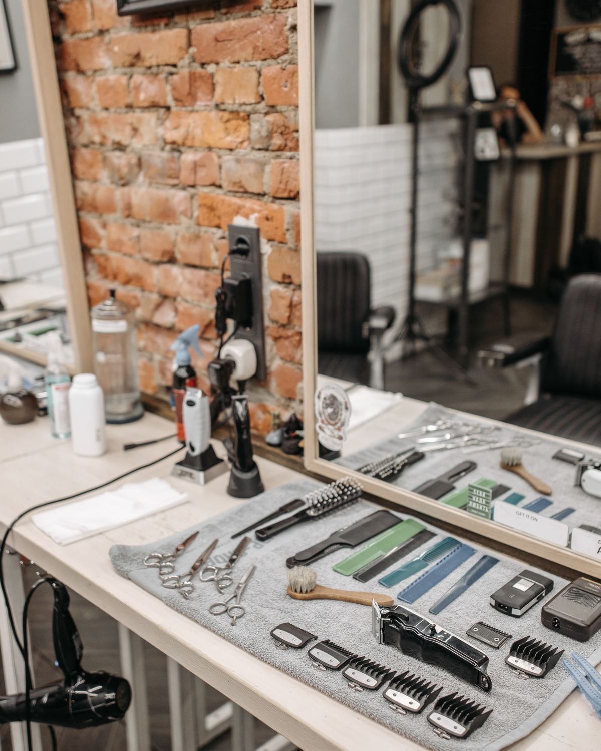 Clippers, scissors and brushes laid out on a counter
