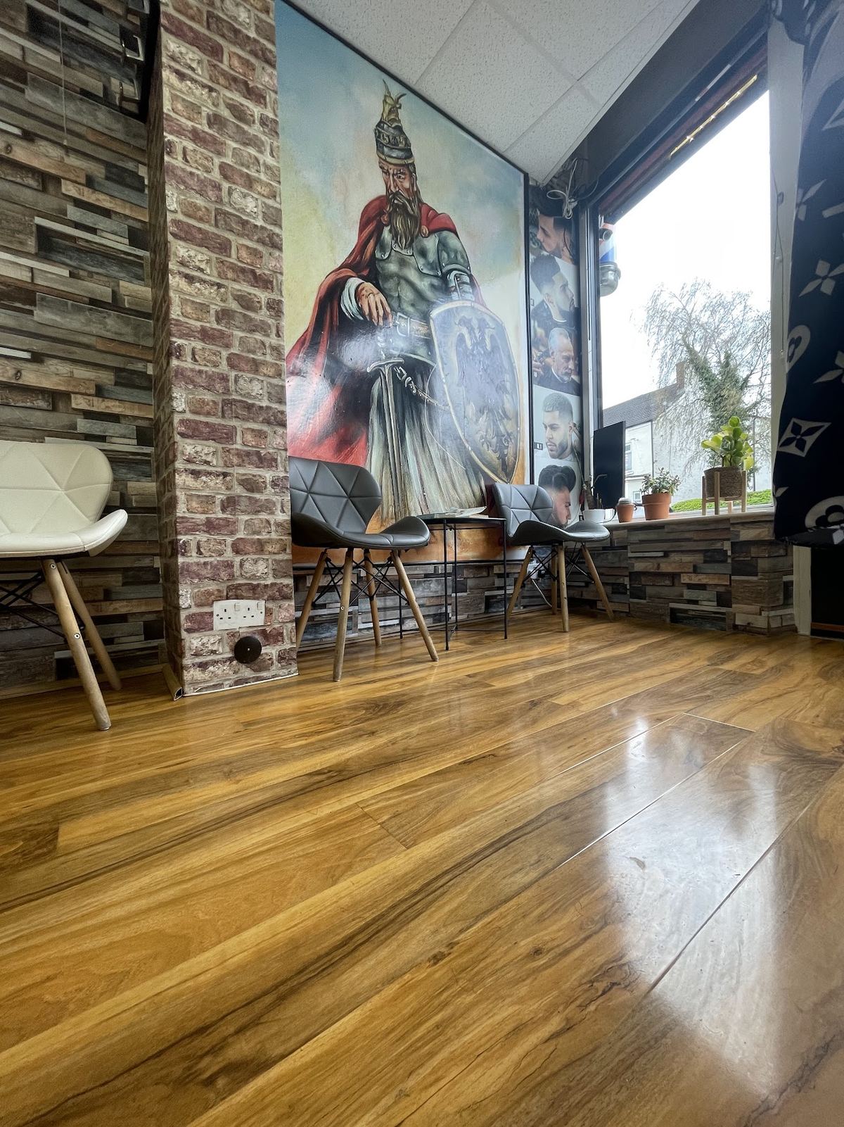 The waiting area inside G&J Barber, with its painted mural and stone-clad wall