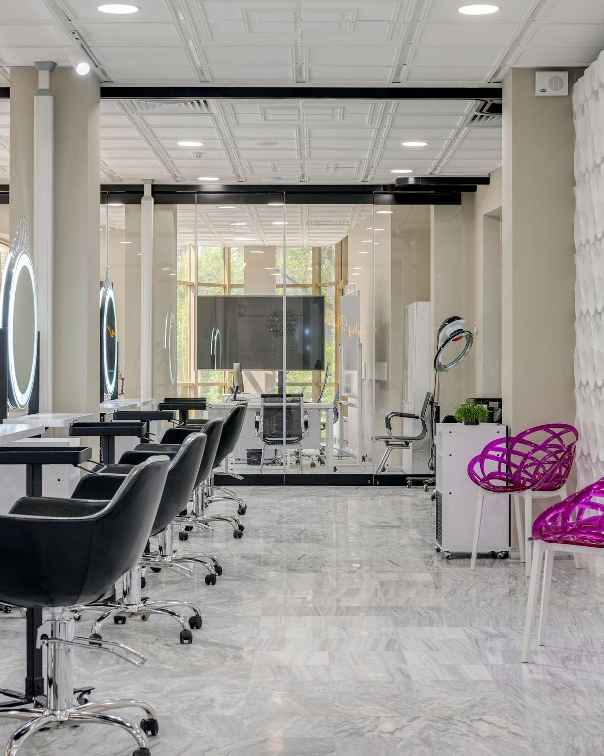 A bright salon with styling stations and lit mirrors