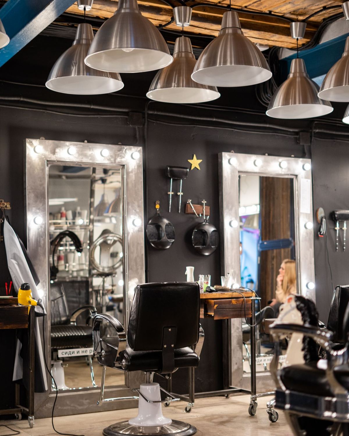A salon styling station with lit mirrors