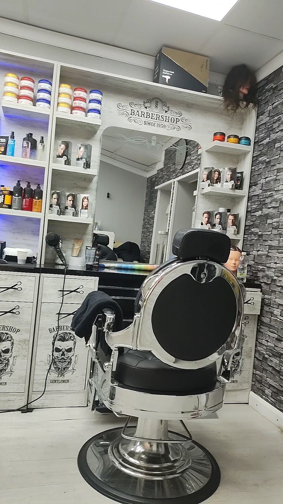 A barber chair at Jian's Barbers, mirrors and product shelves behind