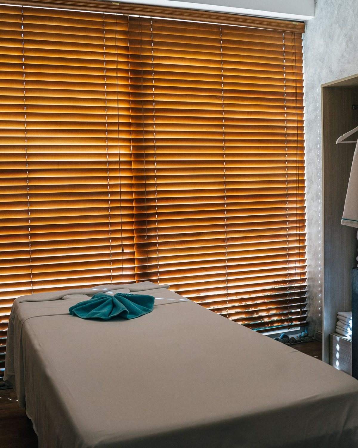 A treatment couch beside wooden blinds