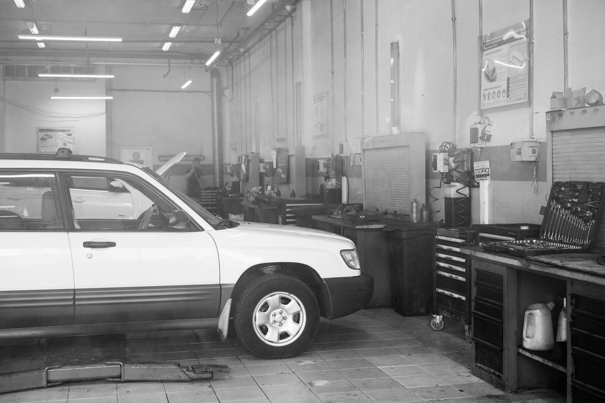 A garage workshop with tool chests and a car in for work