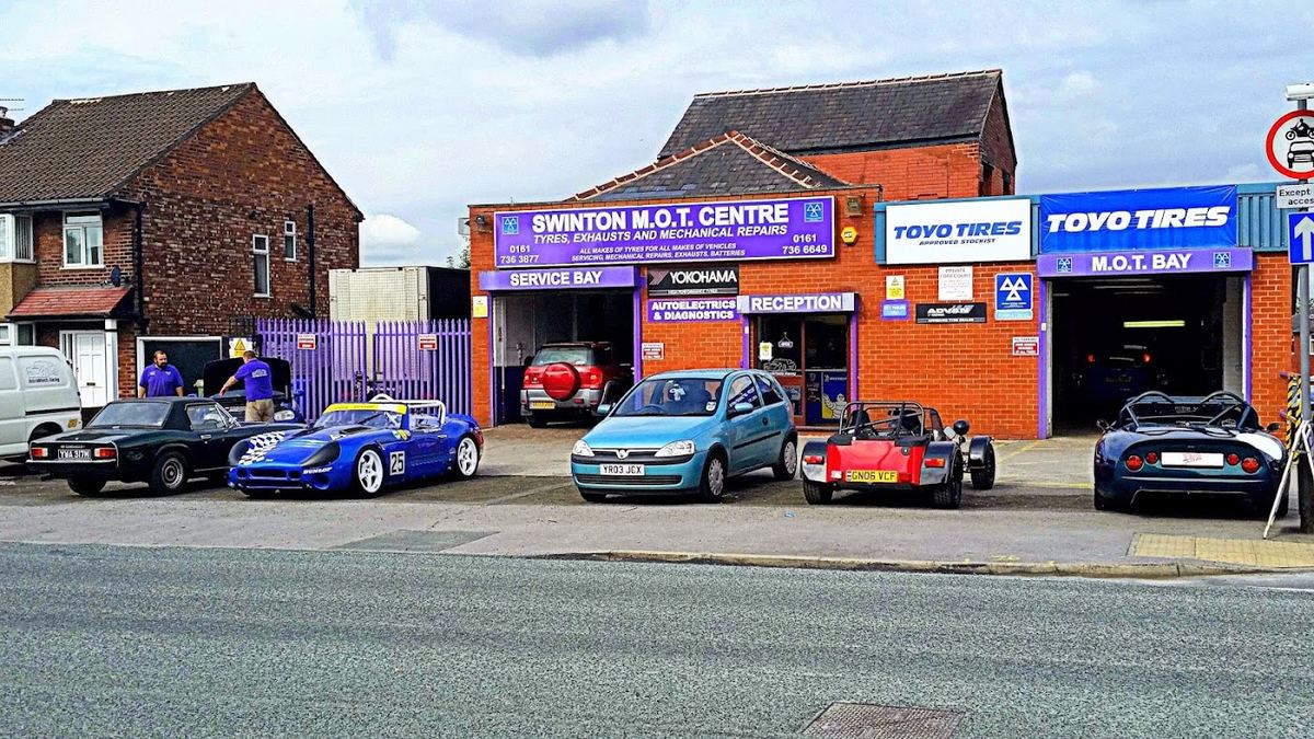 The Swinton M.O.T. Centre shopfront on Bolton Road, cars parked outside the service and MOT bays
