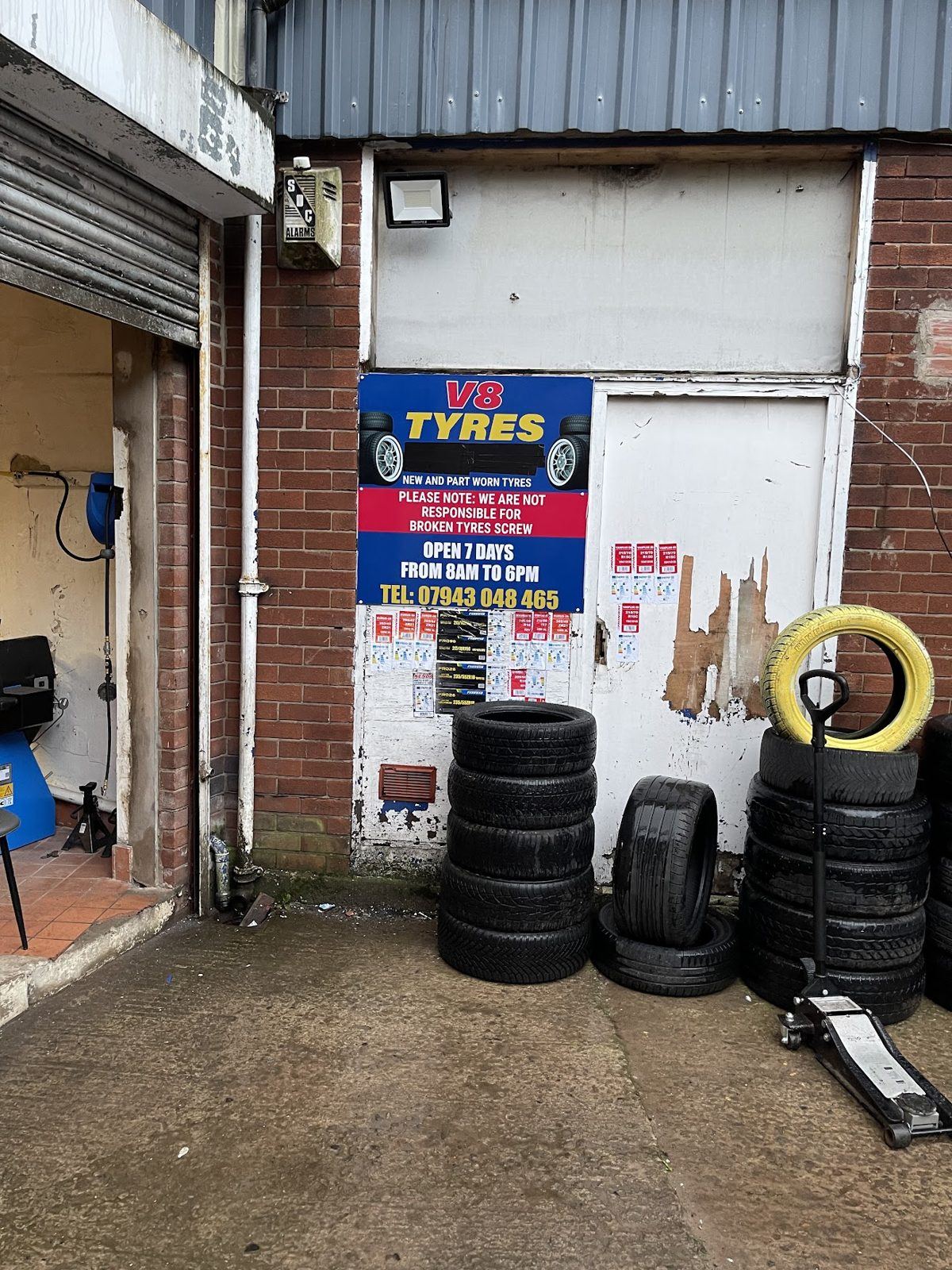 The V8 Tyres unit on Bolton Road, their own sign on the brick and tyres stacked outside